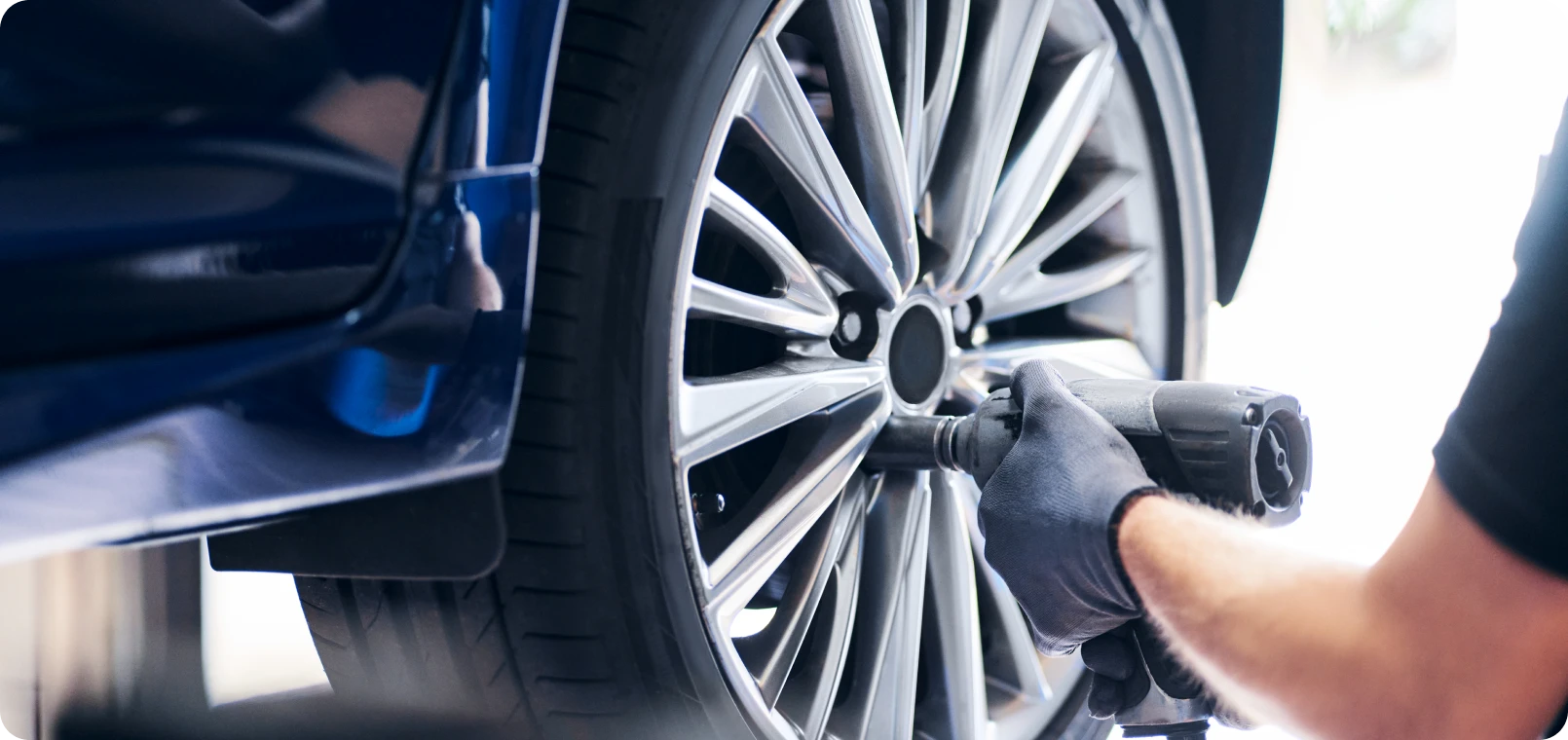 Mechanic tightening car wheel with tool
